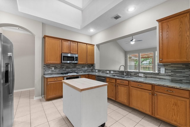 31 Trilling Bird Pl, The Woodlands, TX 77384 - kitchen featuring appliances with stainless steel finishes, a ceiling fan, arched walkways, tasteful backsplash, and recessed lighting