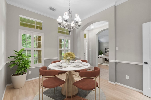 31 Trilling Bird Pl, The Woodlands, TX 77384 - dining room featuring arched walkways, light wood-type flooring, crown molding, and a chandelier