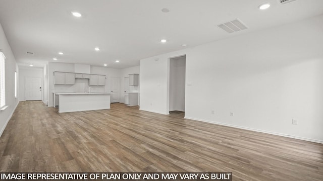 522 Belle Springs Ln, Conroe, TX 77301 - unfurnished living room with recessed lighting, baseboards, light wood finished floors, and visible vents