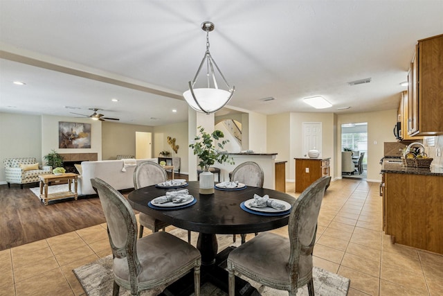 7107 Grant Dr, Magnolia, TX 77354 - dining area with light tile patterned floors, ceiling fan, a fireplace, and recessed lighting