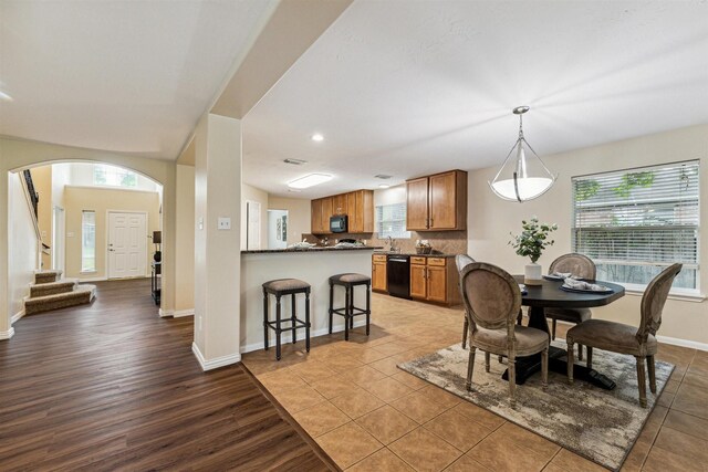 7107 Grant Dr, Magnolia, TX 77354 - dining area featuring stairs, baseboards, arched walkways, light wood-type flooring, and recessed lighting
