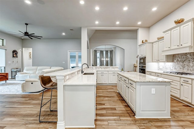 12306 Wildrye Prairie Trce, Humble, TX 77346 - kitchen featuring a kitchen island with sink, open floor plan, a sink, and stainless steel appliances