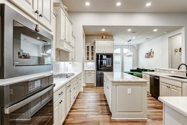 12306 Wildrye Prairie Trce, Humble, TX 77346 - kitchen with a center island, a sink, light wood-style floors, and appliances with stainless steel finishes