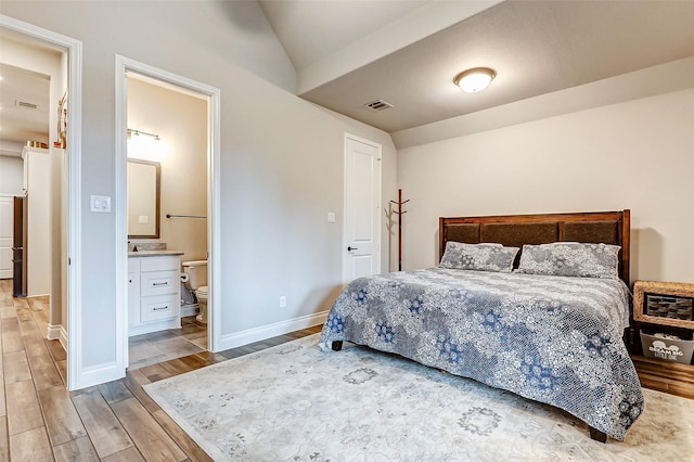 12306 Wildrye Prairie Trce, Humble, TX 77346 - bedroom featuring lofted ceiling, light wood-type flooring, ensuite bathroom, baseboards, and visible vents