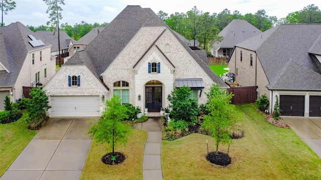 12306 Wildrye Prairie Trce, Humble, TX 77346 - french provincial home with stone siding, concrete driveway, a front yard, brick siding, and roof with shingles