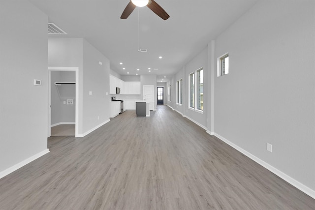 5028 Marcasca Dr, Katy, TX 77493 - unfurnished living room featuring visible vents, baseboards, a ceiling fan, and wood finished floors