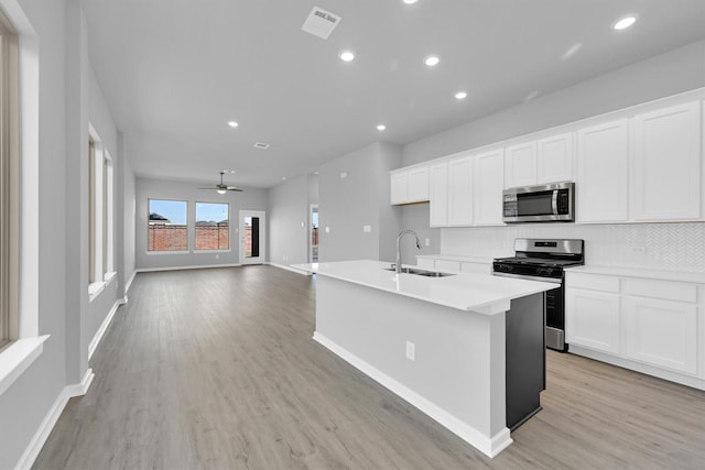 5028 Marcasca Dr, Katy, TX 77493 - kitchen featuring baseboards, light wood-style flooring, white cabinetry, stainless steel appliances, and a sink