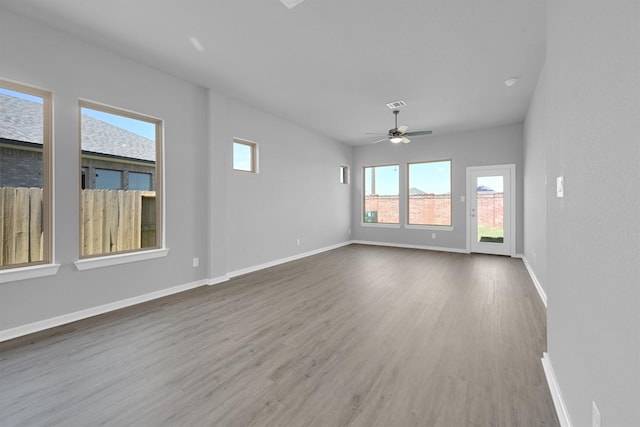 5028 Marcasca Dr, Katy, TX 77493 - unfurnished living room with a wealth of natural light, baseboards, a ceiling fan, and wood finished floors