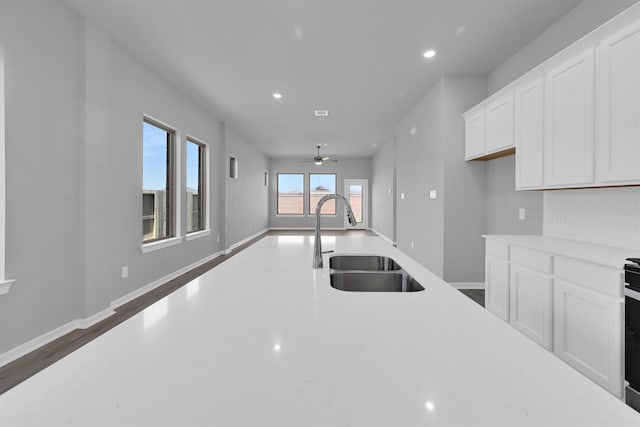 5028 Marcasca Dr, Katy, TX 77493 - kitchen with white cabinets, a sink, light countertops, ceiling fan, and recessed lighting