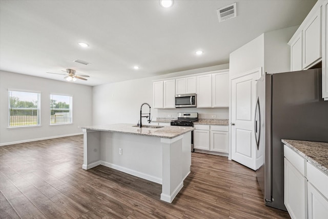 12260 Lady Eli Dr, Willis, TX 77318 - kitchen with appliances with stainless steel finishes, dark wood-type flooring, a ceiling fan, a center island with sink, and recessed lighting