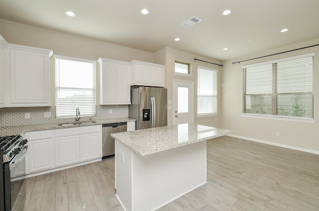 5203 Prairie Terrace Ln, Fulshear, TX 77441 - kitchen with light wood finished floors, a sink, tasteful backsplash, and appliances with stainless steel finishes