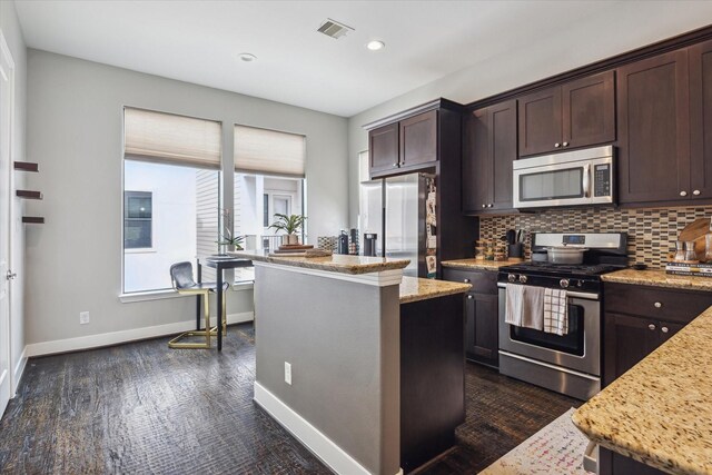 2718 Leeland St Unit A, Houston, TX 77003 - kitchen with appliances with stainless steel finishes, dark brown cabinetry, baseboards, a kitchen island, and recessed lighting