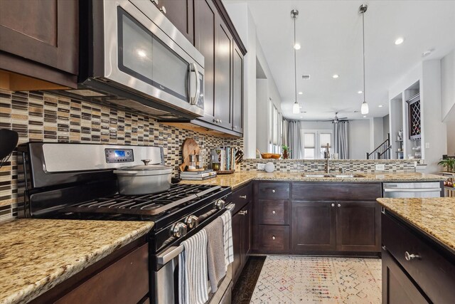 2718 Leeland St Unit A, Houston, TX 77003 - kitchen with appliances with stainless steel finishes, a sink, dark brown cabinetry, tasteful backsplash, and light stone countertops