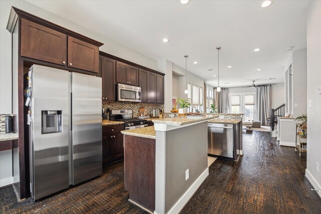 2718 Leeland St Unit A, Houston, TX 77003 - kitchen featuring appliances with stainless steel finishes, dark brown cabinets, tasteful backsplash, open floor plan, and recessed lighting