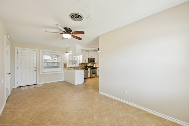 unfurnished living room featuring light tile patterned floors, baseboards, visible vents, and a ceiling fan