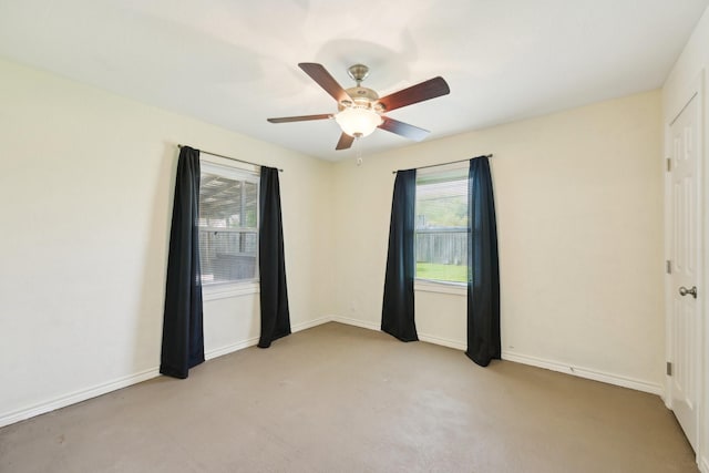 carpeted spare room featuring baseboards and ceiling fan