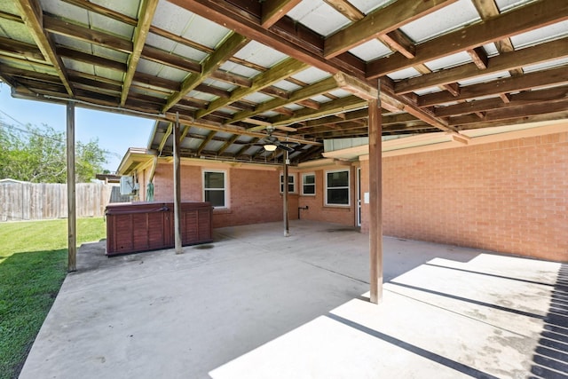 view of patio / terrace with a hot tub, fence, and a ceiling fan