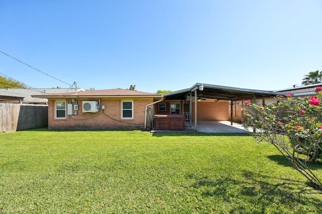 rear view of property featuring a patio, a fenced backyard, a lawn, brick siding, and a hot tub