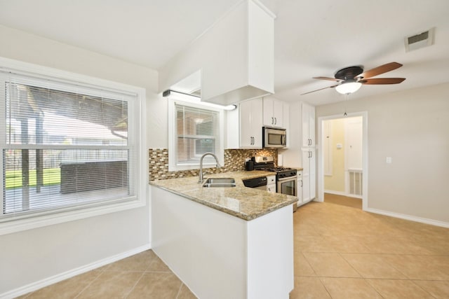 kitchen with light tile patterned flooring, a sink, stainless steel appliances, visible vents, and decorative backsplash