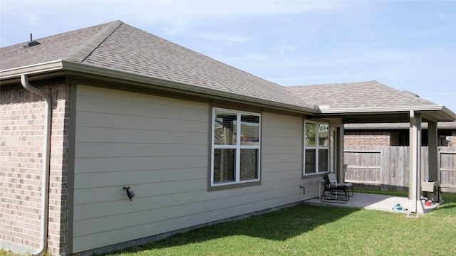 1807 Iris Knoll Ln, Pearland, TX 77089 - rear view of house featuring a yard, fence, a patio, brick siding, and roof with shingles