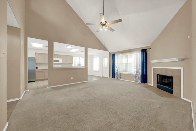 2904 Bristol Bend Ln, Dickinson, TX 77539 - unfurnished living room featuring high vaulted ceiling, ceiling fan, baseboards, a tiled fireplace, and light carpet