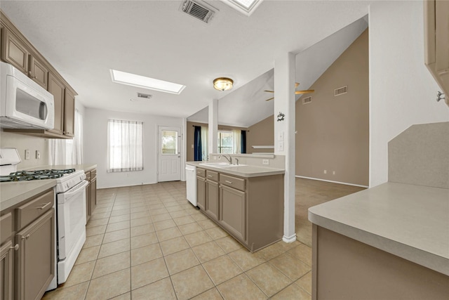 2904 Bristol Bend Ln, Dickinson, TX 77539 - kitchen with white appliances, a sink, light countertops, light tile patterned floors, and lofted ceiling