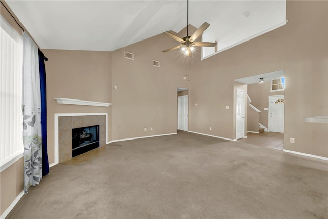 2904 Bristol Bend Ln, Dickinson, TX 77539 - unfurnished living room with ceiling fan, high vaulted ceiling, carpet floors, a tiled fireplace, and stairs