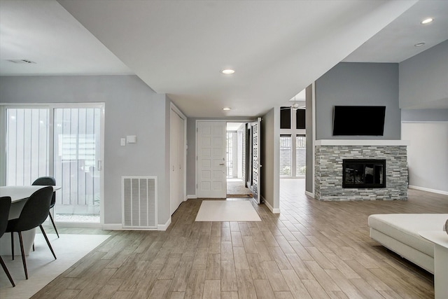 foyer featuring baseboards, wood finished floors, and visible vents