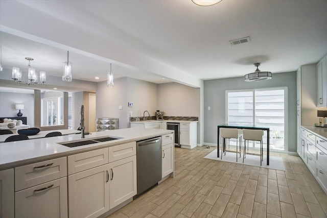 kitchen with wine cooler, light wood-style flooring, a sink, visible vents, and dishwasher