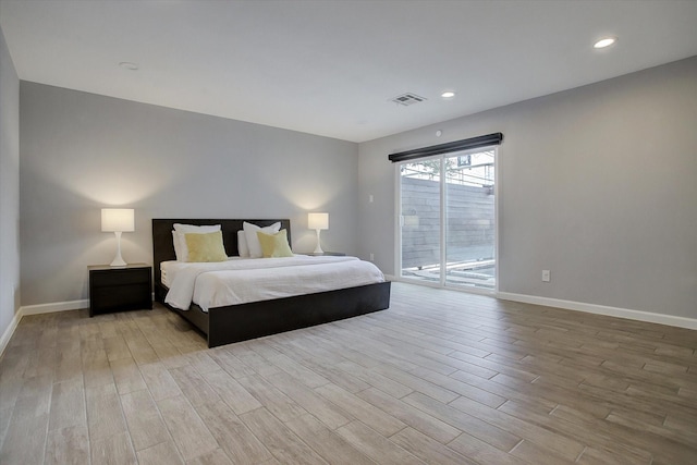 bedroom featuring wood finished floors, visible vents, baseboards, and access to outside