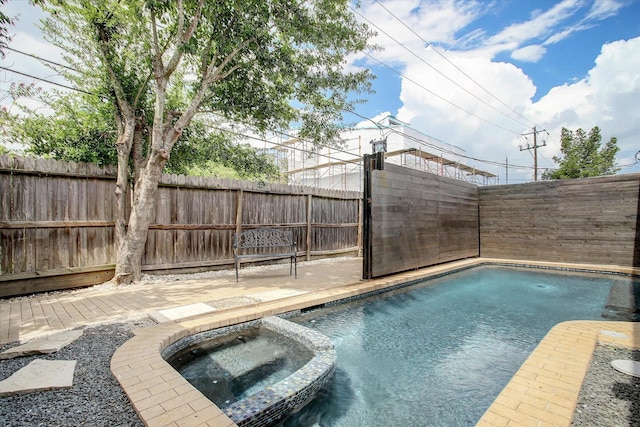 view of swimming pool featuring fence and a pool with connected hot tub