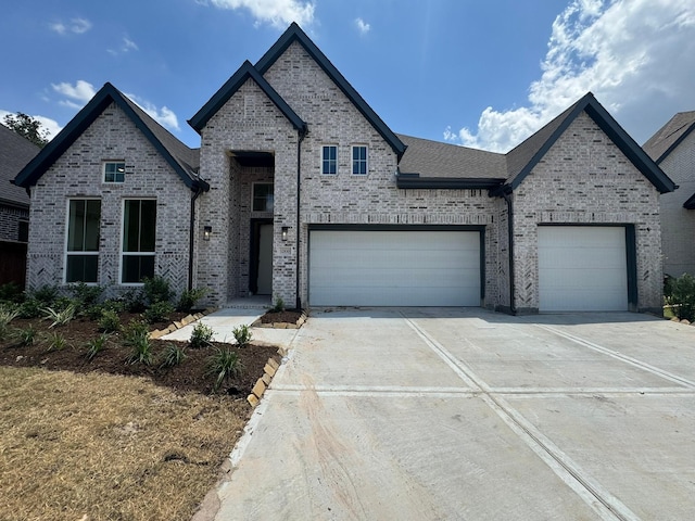 12830 Forest Garden Ct, Conroe, TX 77302 - french country inspired facade with concrete driveway, brick siding, and an attached garage