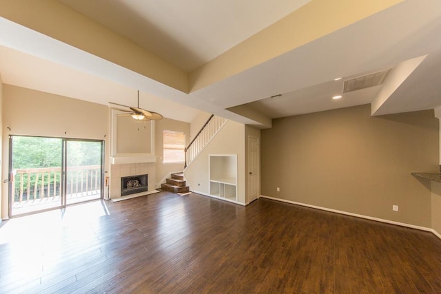 737 Davis Rd, League City, TX 77573 - unfurnished living room with visible vents, baseboards, a tiled fireplace, ceiling fan, and dark wood-style floors