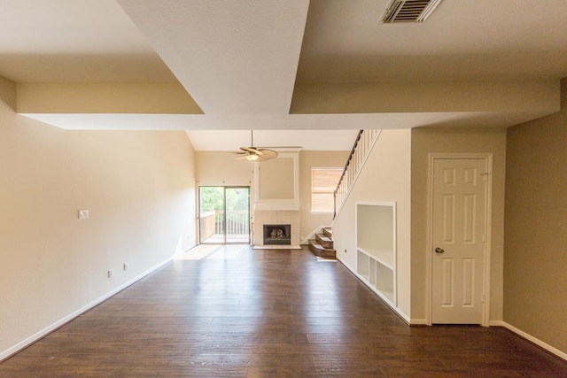 737 Davis Rd, League City, TX 77573 - unfurnished living room featuring dark wood-style flooring, baseboards, a ceiling fan, visible vents, and a tile fireplace
