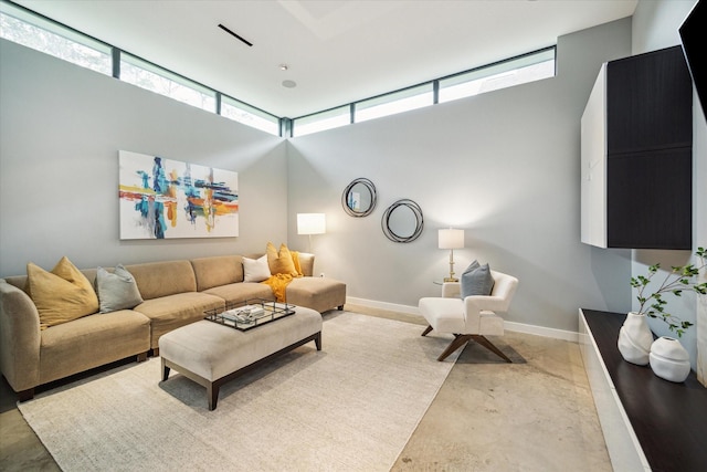 living area featuring concrete flooring and baseboards