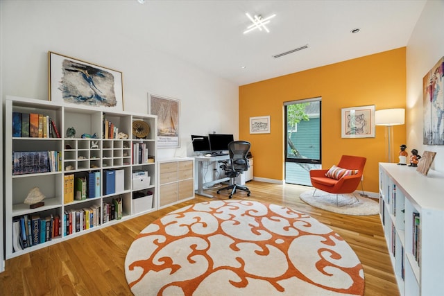 office space featuring visible vents, baseboards, and wood finished floors