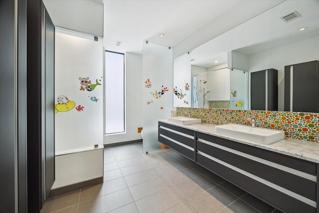 full bath with a shower stall, tile patterned flooring, visible vents, a sink, and double vanity