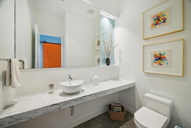 bathroom featuring toilet, vanity, and visible vents
