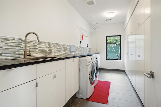 laundry area featuring tile patterned flooring, visible vents, independent washer and dryer, cabinet space, and a sink
