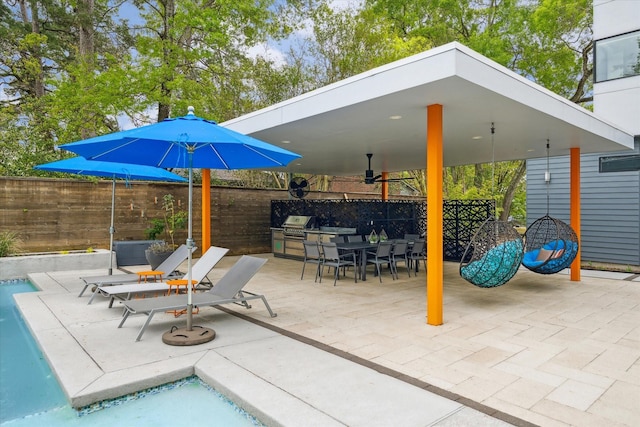 view of patio featuring exterior kitchen, outdoor dining area, and fence