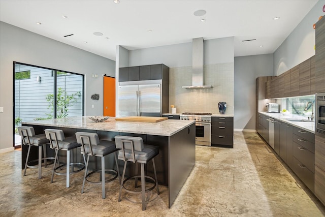 kitchen featuring tasteful backsplash, modern cabinets, wall chimney range hood, high quality appliances, and a spacious island