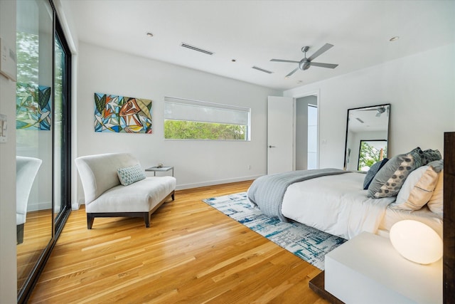 bedroom featuring light wood-style flooring, ceiling fan, baseboards, and visible vents