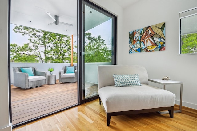 sitting room with wood finished floors, ceiling fan, and baseboards