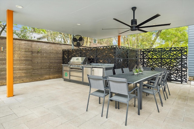 view of patio / terrace featuring outdoor dining space, an outdoor kitchen, grilling area, a ceiling fan, and fence