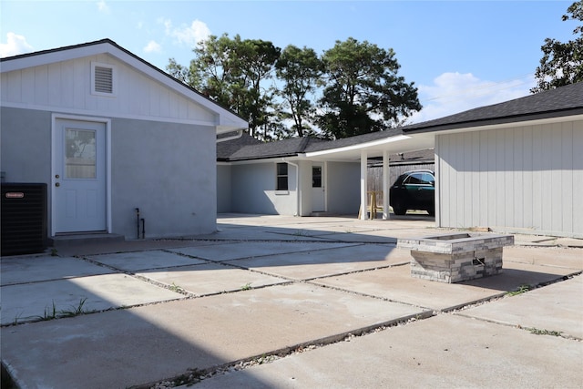 9121 Fordshire Dr, Houston, TX 77025 - rear view of house with a carport, central AC, driveway, and stucco siding