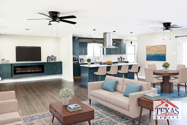 9121 Fordshire Dr, Houston, TX 77025 - living area featuring baseboards, a ceiling fan, dark wood finished floors, recessed lighting, and a glass covered fireplace