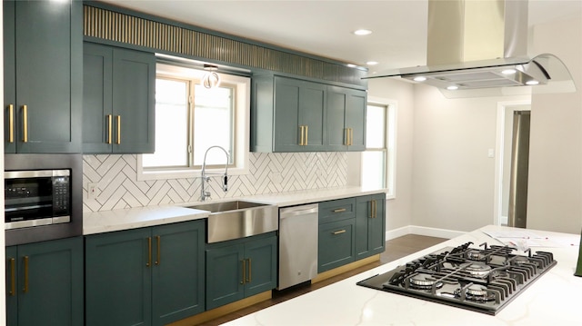 9121 Fordshire Dr, Houston, TX 77025 - kitchen featuring a sink, island exhaust hood, green cabinets, decorative backsplash, and stainless steel appliances