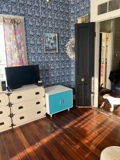 interior space featuring dark wood-style floors, visible vents, and wallpapered walls
