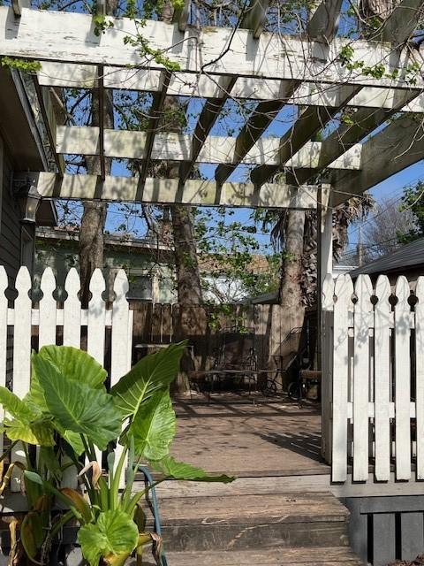 surrounding community with a pergola, a wooden deck, and fence