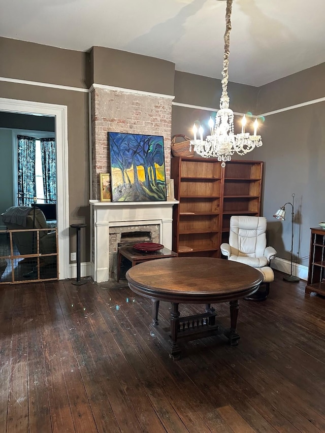 interior space featuring baseboards, a chandelier, hardwood / wood-style flooring, and a fireplace